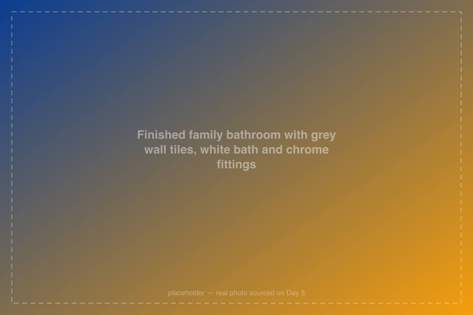 Finished family bathroom with grey wall tiles, white bath and chrome fittings